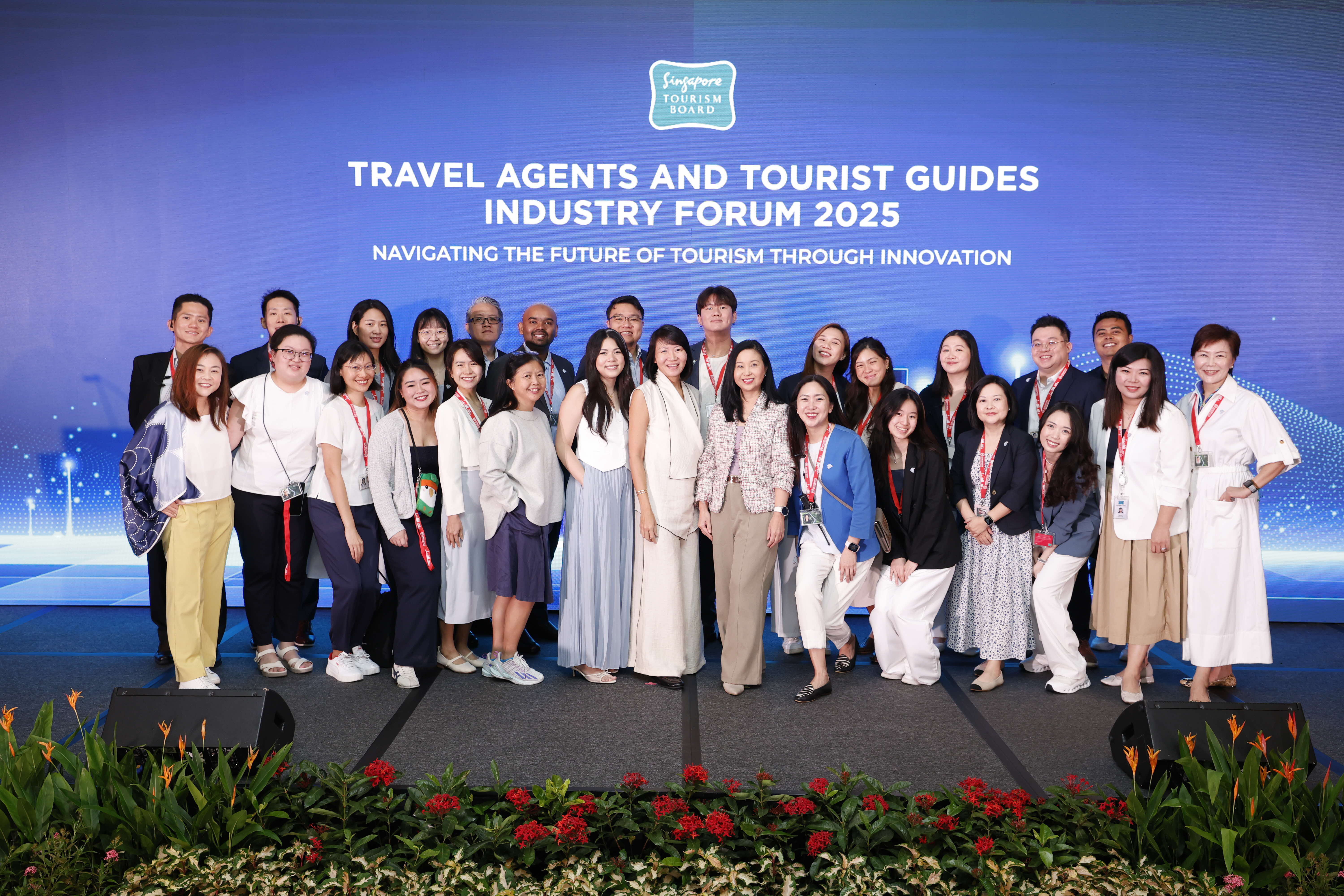 Group photo of the STB's Travel Agents and Tourist Guides Division team standing in front of the event banner.